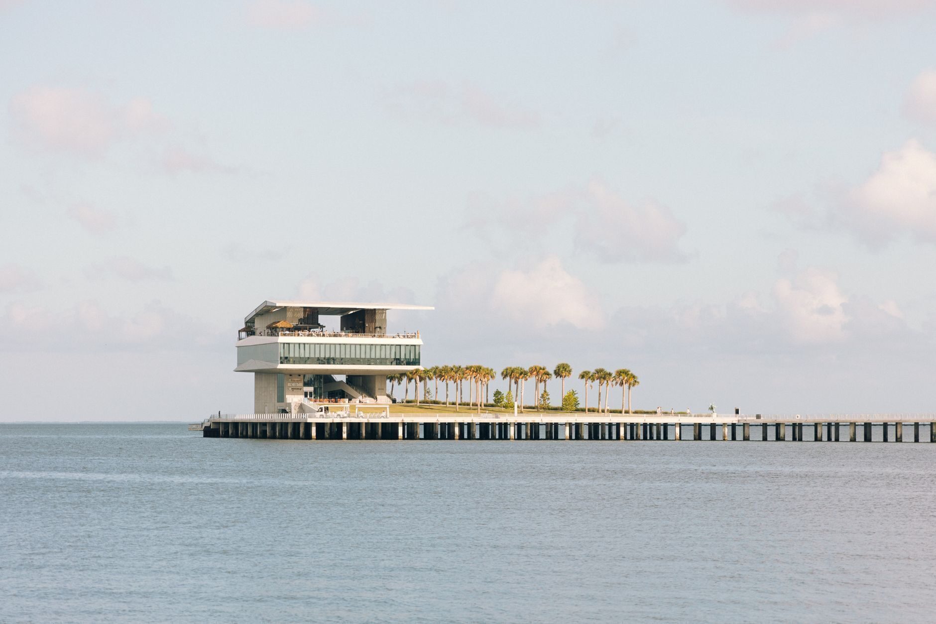 The St. Pete Pier reaching into Tampa Bay, lined with palm trees under a soft sky